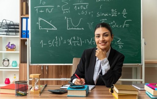 smiling-young-female-teacher-sits-table-with-schoo